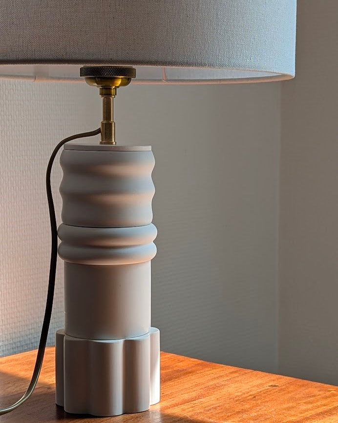 Pied de la Lampe Innovante Sentinelle Blanche Illari illuminé par le soleil.