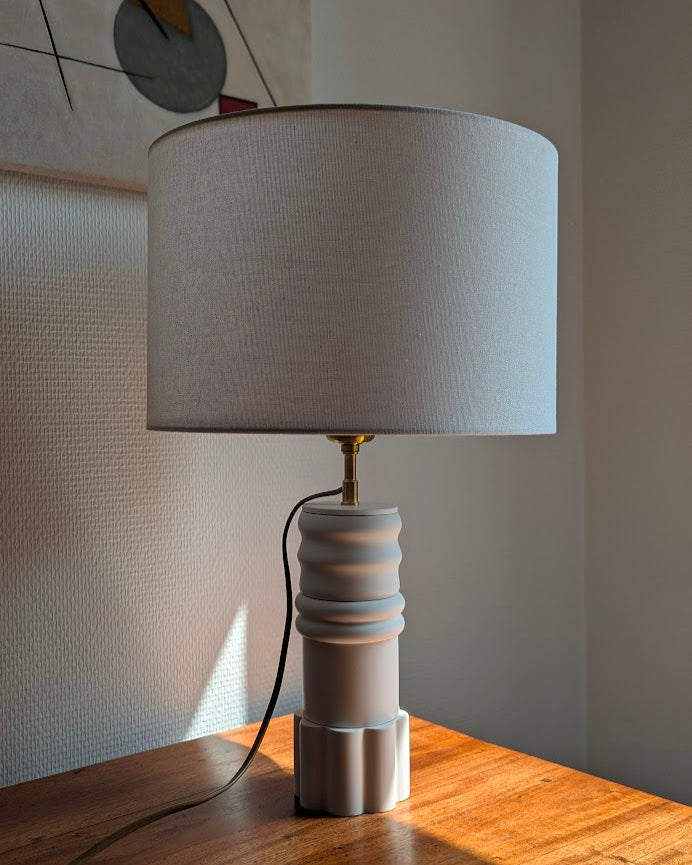 Vue d'ensemble de la Lampe Illari, modèle Sentinelle Blanche légèrement illuminée par le soleil.