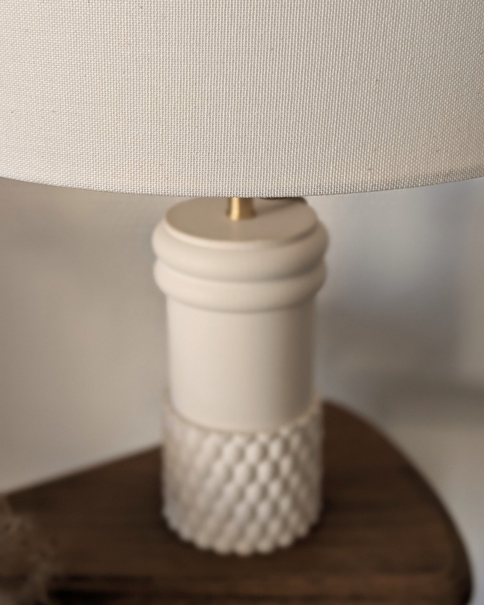 Zoom sur Lampe Raffiné Ambre Blanc Illari sur son piédestal.