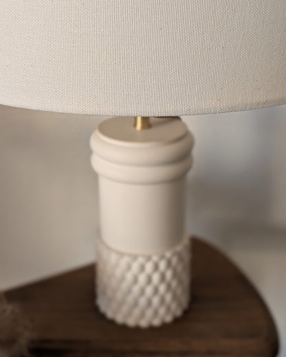 Zoom sur Lampe Raffiné Ambre Blanc Illari sur son piédestal.
